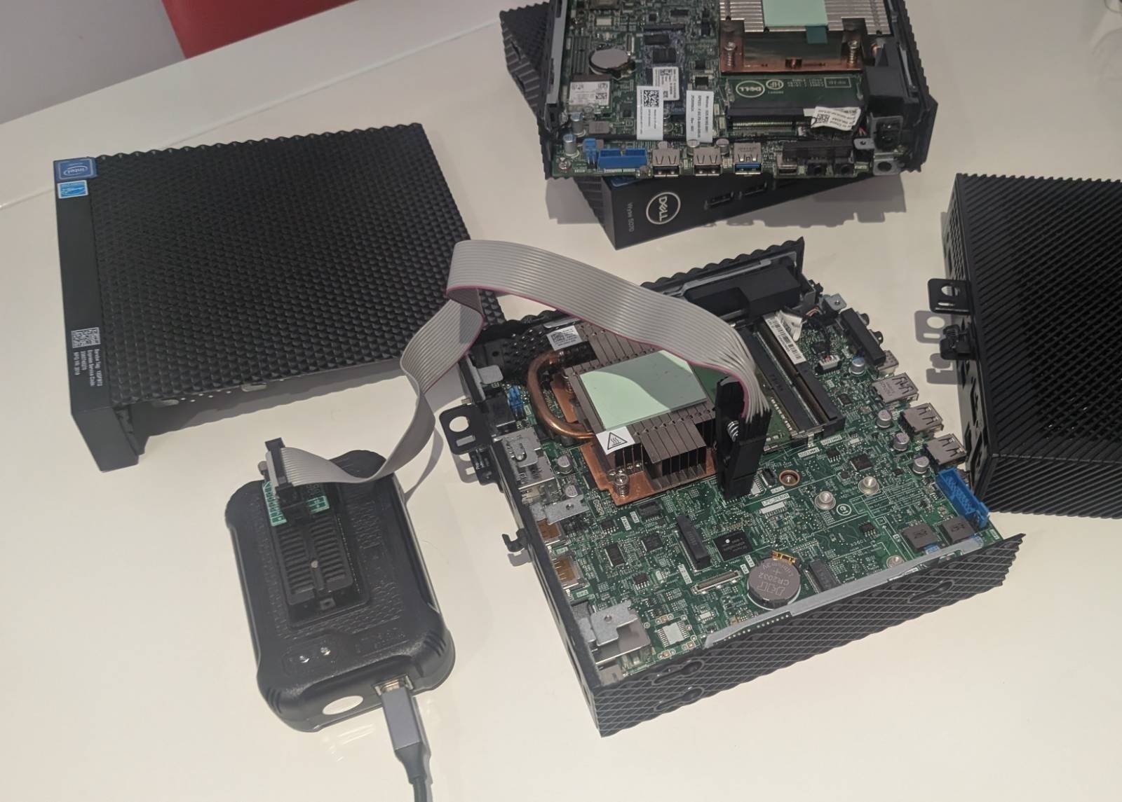 A SOIC-8 clip on the BIOS flash chip, connected to a T48 programmer. This is the whole hardware requirement: no soldering, no board removal.